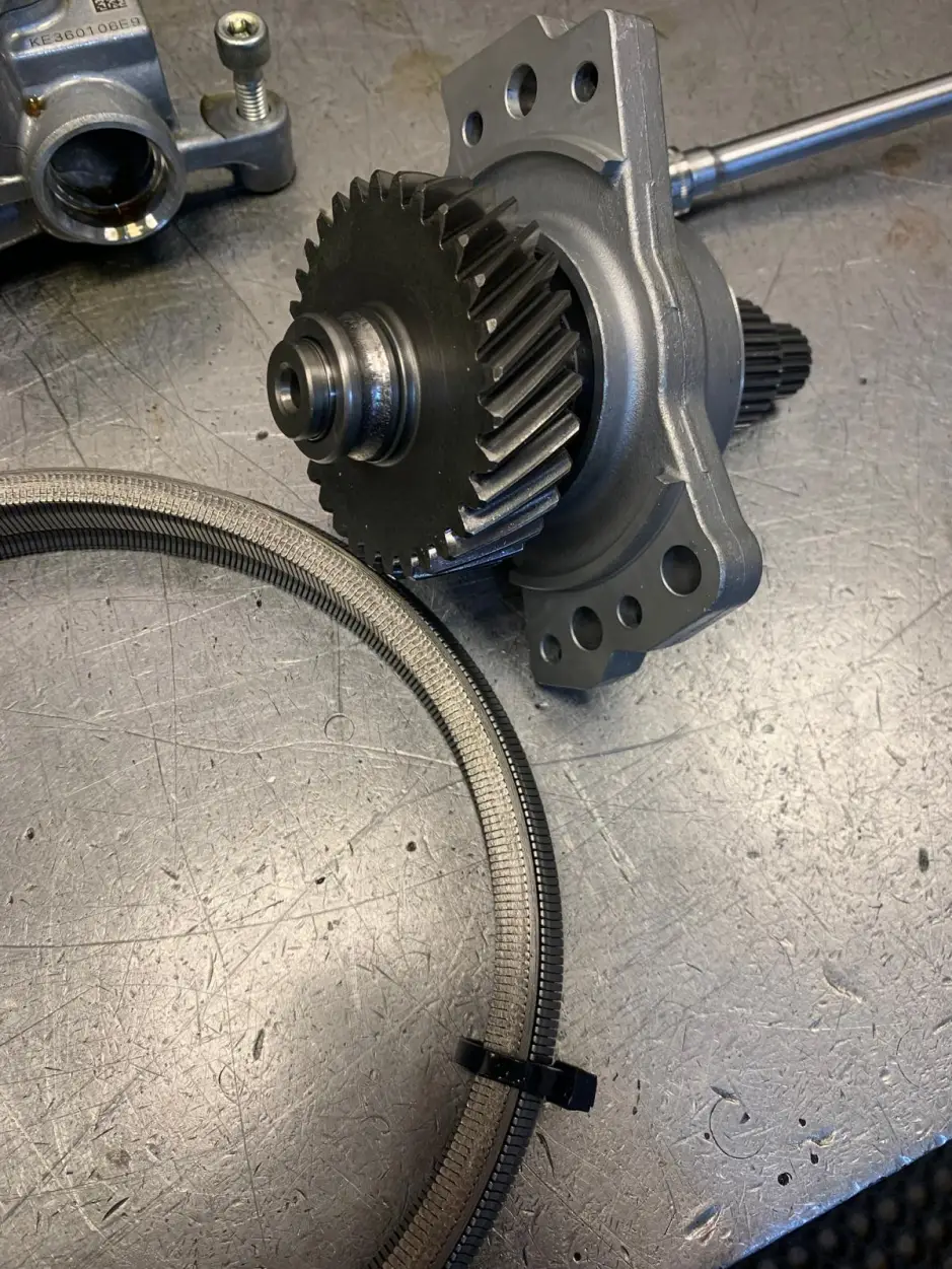 Close-up of Nissan gearbox oil pump assembly and helical gear on workshop bench