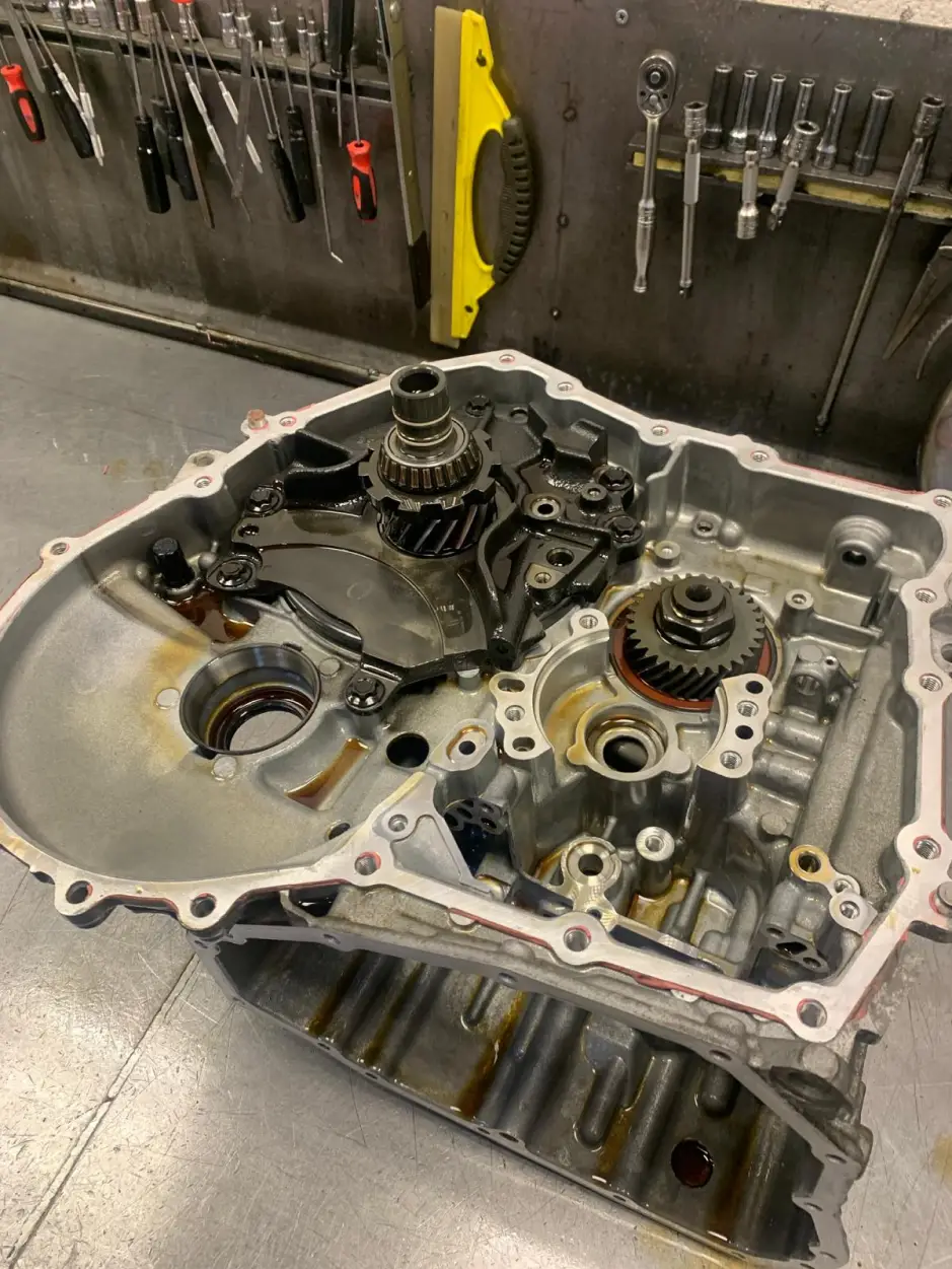 Opened Nissan gearbox casing showing internal gears and differential during transmission rebuild